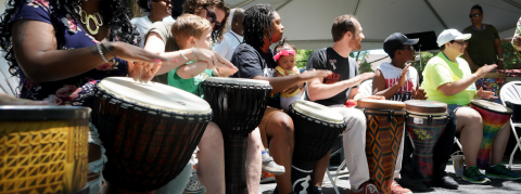 People are playing drums while facing right.